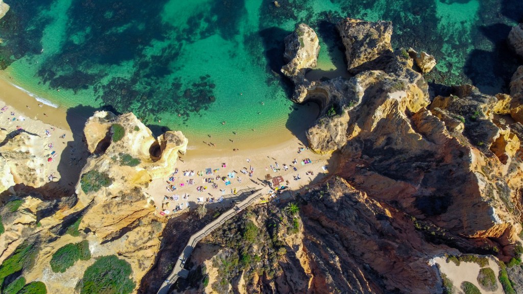 Widok z lotu ptaka na Praia do Camilo z turkusową wodą i plażowiczami