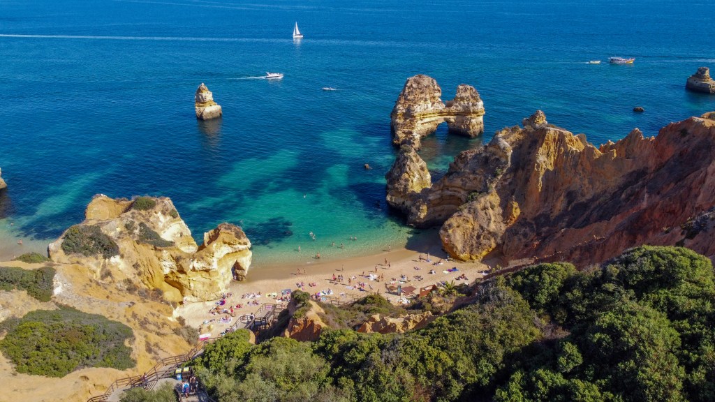 Lotniczy widok na Praia do Camilo z turkusową wodą i złotymi klifami