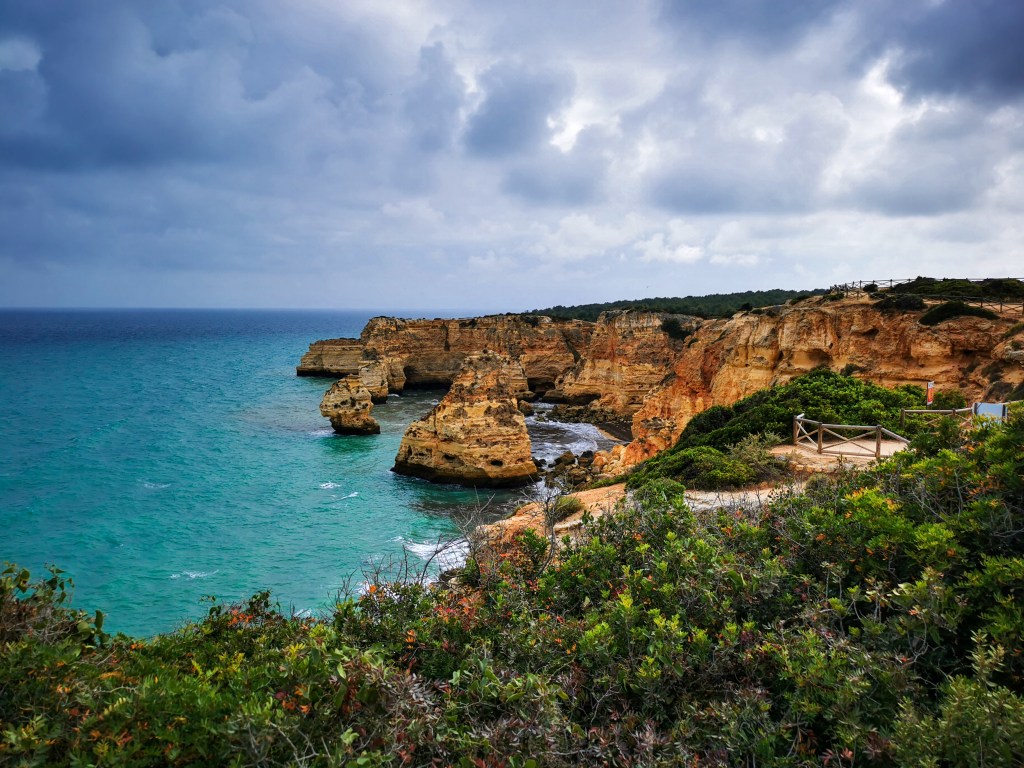 Punkt widokowy na Praia da Marinha z klifami i zielenią.