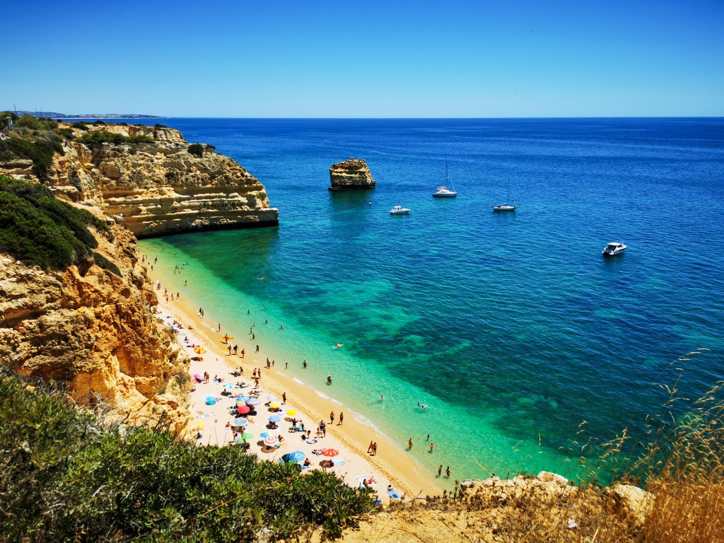 Widok na Praia da Marinha w Algarve z wysokiego klifu, turkusowe morze, łodzie i plażowicze na piasku