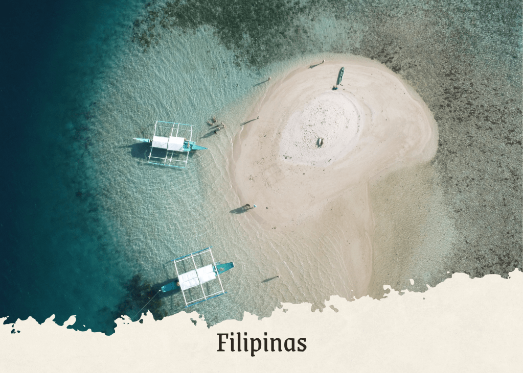 Vista aérea de uma pequena ilha nas Filipinas, com barcos de pesca ancorados nas águas cristalinas e uma praia de areia branca ao redor.