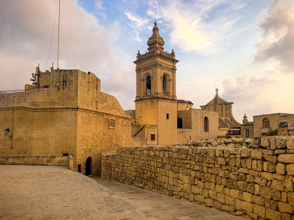 Torres defensivas, muralhas e campanários da Cittadella iluminados ao entardecer, Victoria, Gozo