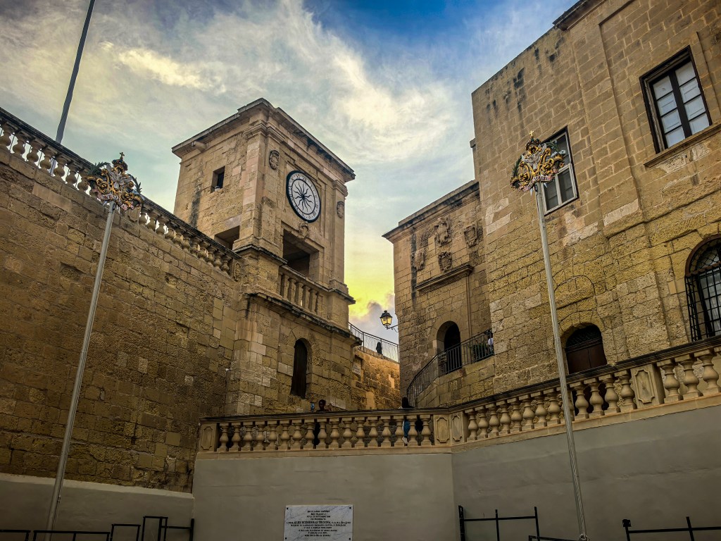 Torre do relógio e edifícios históricos em pedra dourada ao pôr-do-sol, Cittadella, Victoria, Gozo, Malta