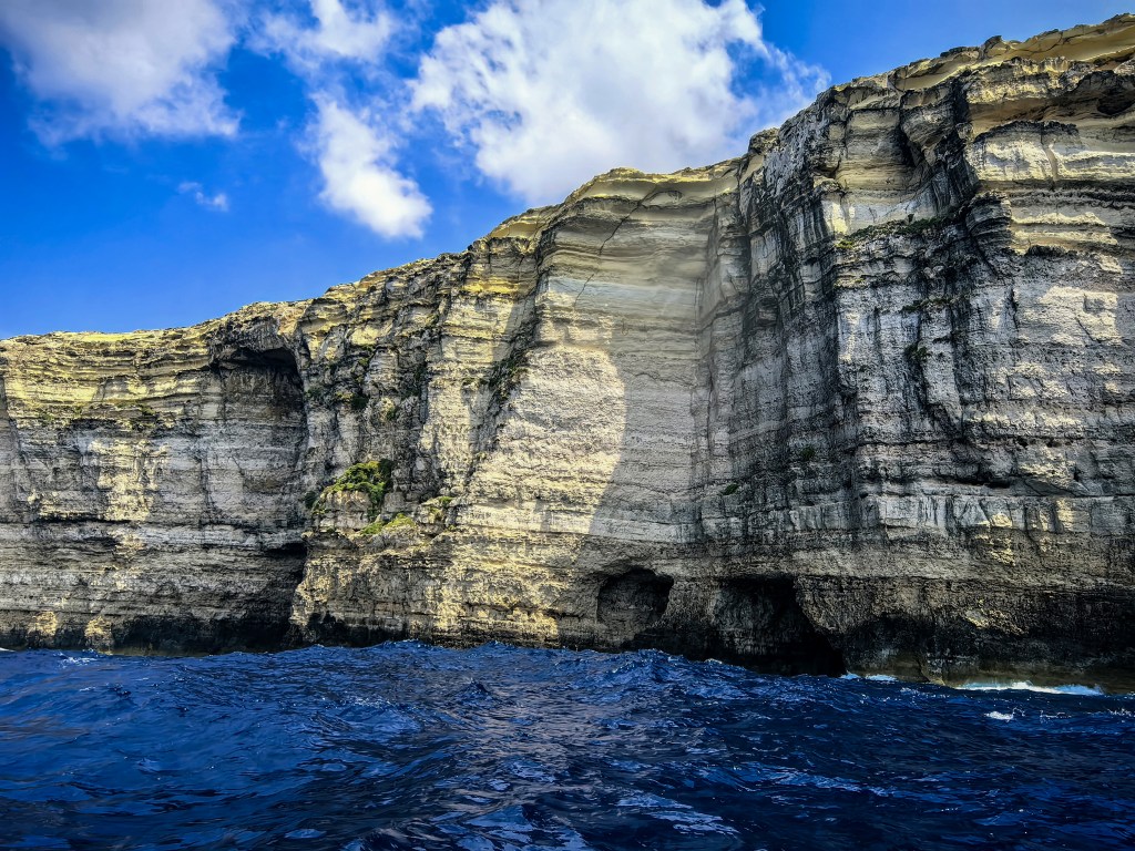 Altas falésias em camadas, com paredes calcárias dramáticas junto ao mar azul, Gozo, Malta