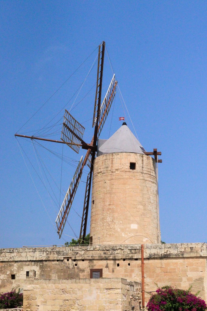 Historyczny kamienny wiatrak Ta’ Kola z czterema skrzydłami na tle błękitnego nieba, Gozo, Malta