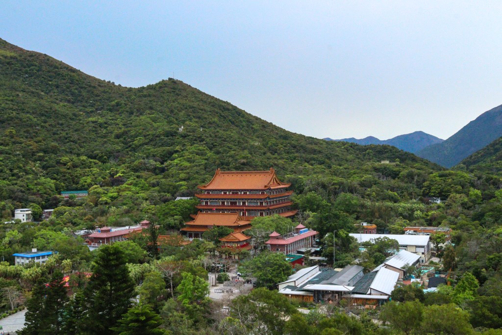 Vista panorâmica do Mosteiro Po Lin rodeado por montanhas verdes, Ilha de Lantau, Hong Kong.