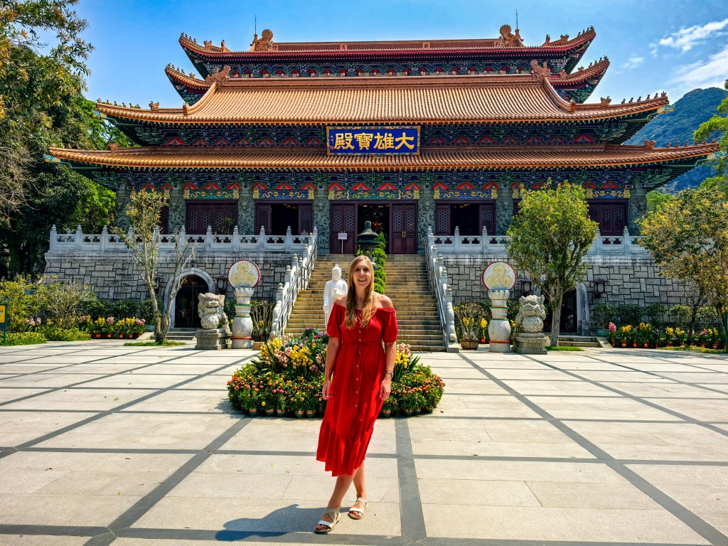 Main hall of Po Lin Monastery with a visitor in a red dress in front, Tian Tan Buddha area, Hong Kong.