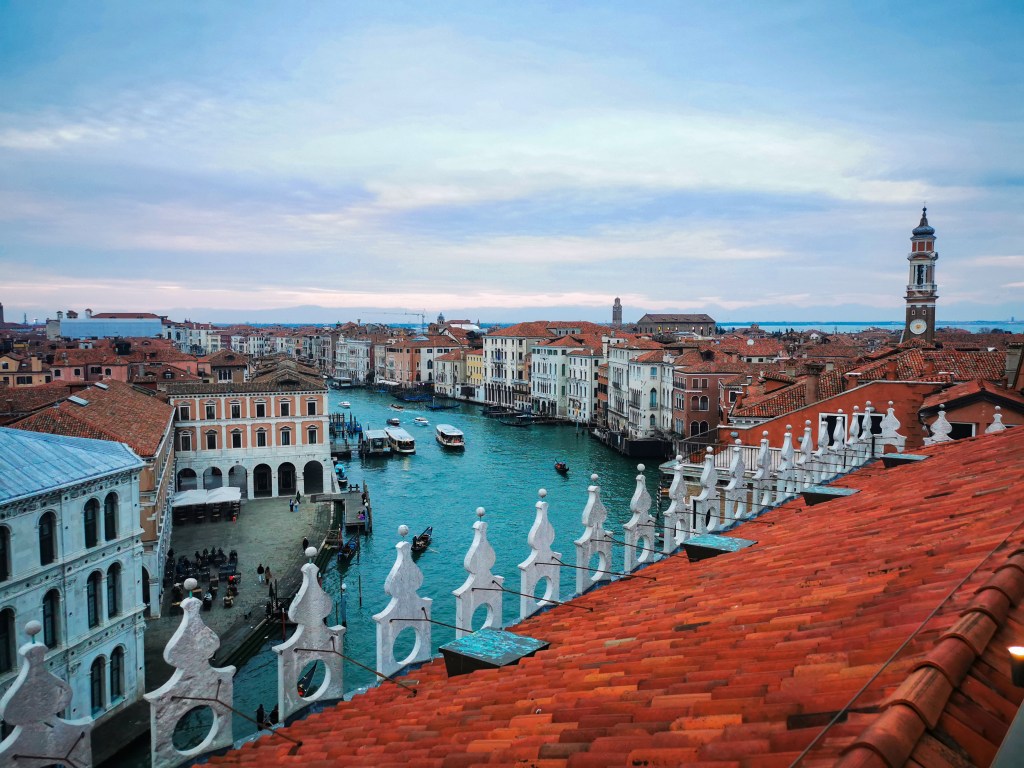Veneza: Tudo o que deves saber antes da tua viagem Panorama dos telhados e canais de Veneza visto do terraço do Fondaco dei Tedeschi