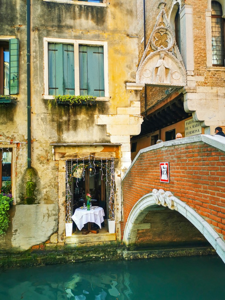 Veneza: Tudo o que deves saber antes da tua viagem Restaurante romântico junto ao canal em Veneza com mesa à beira da água