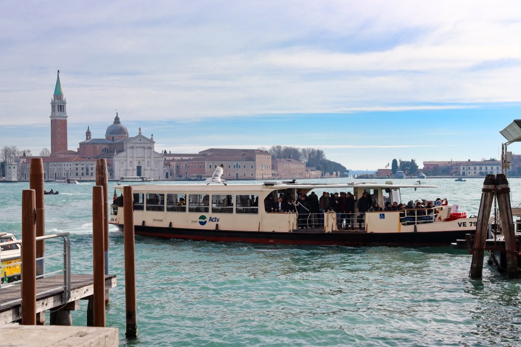 Venice: Everything You Should Know Before Your Trip Vaporetto water bus crossing the Venice lagoon with San Giorgio Maggiore in the background.