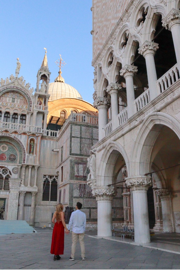 Venice: Everything You Should Know Before Your Trip Couple holding hands between St Mark’s Basilica and the Doge’s Palace in Venice.