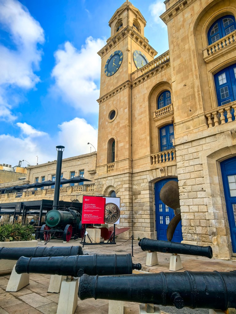 Malta Maritime Museum w Birgu z historyczną lokomotywą parową i armatami na ekspozycji.