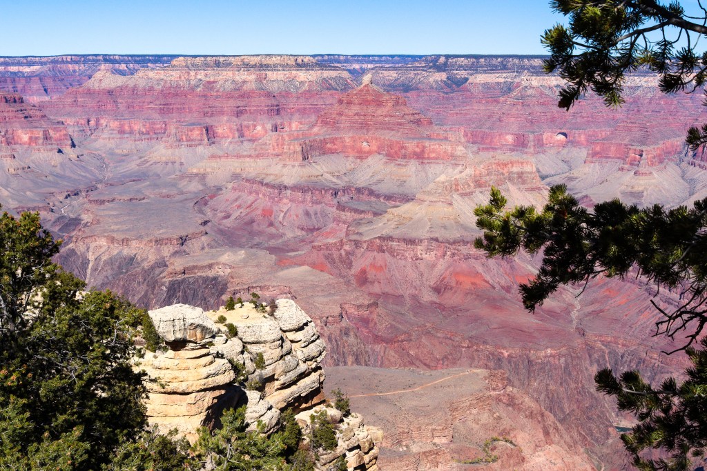 Rocky outcrop at the Grand Canyon South Rim overlooking colorful canyon layers