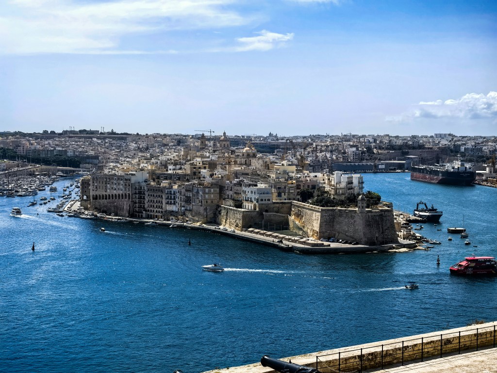 Panoramiczny widok na ufortyfikowane miasteczko Isla i Grand Harbour z Upper Barrakka Gardens w Valletcie.