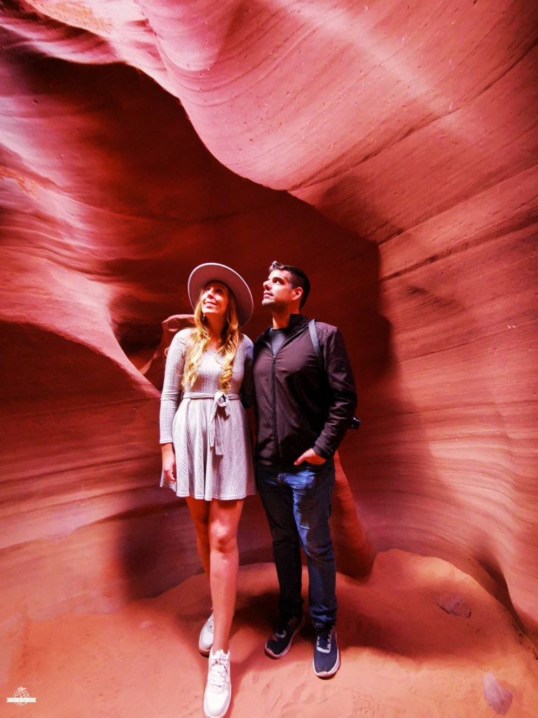 Visitors standing inside Antelope Canyon surrounded by red sandstone walls in Arizona