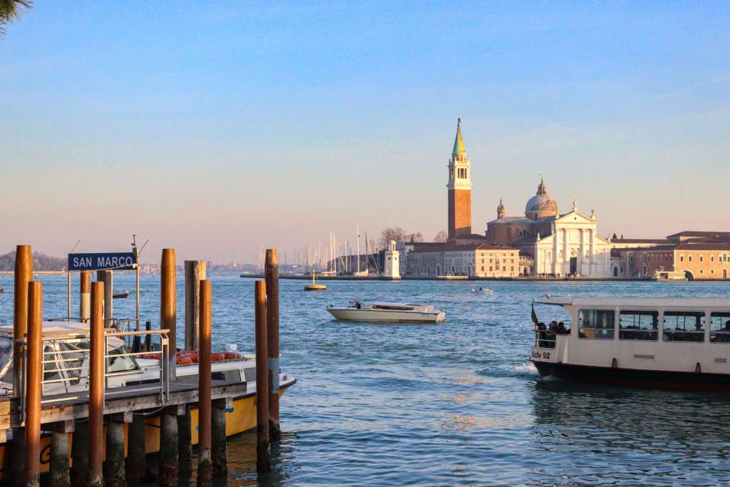 Wenecja – jak się poruszać po Mieście Dożów? Przystań San Marco w Wenecji. Widok na przepływającą łóðź i vaporetto oraz San Giorgio Maggiore.