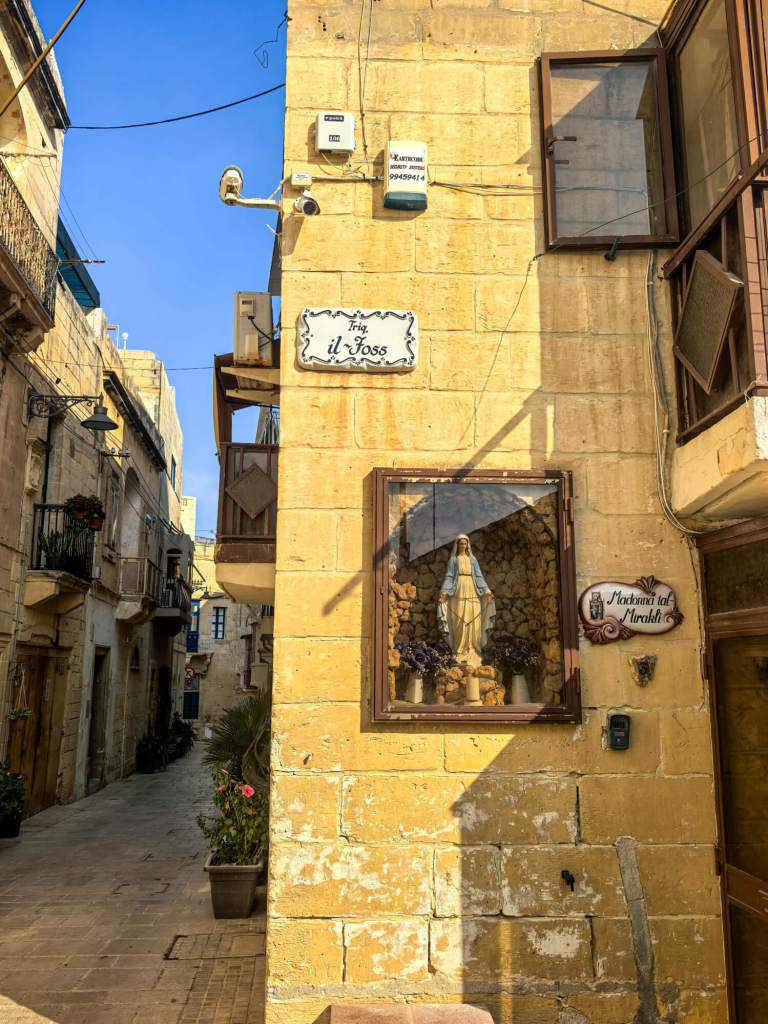 A Guide to Malta’s Three Cities: Discover Birgu, Isla and Bormla A religious street shrine with a statue of the Madonna (Madonna tal-Mirakli) on a limestone corner in Birgu, Malta.