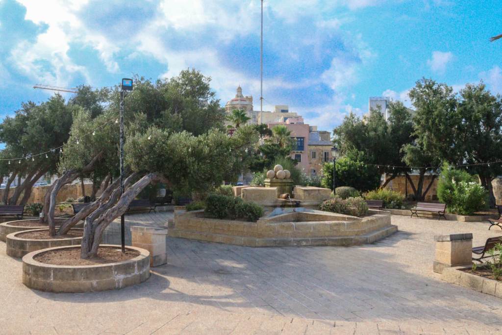 A Guide to Malta’s Three Cities: Discover Birgu, Isla and Bormla A peaceful stone fountain surrounded by ancient olive trees in Gardjola Gardens, Senglea, Malta.