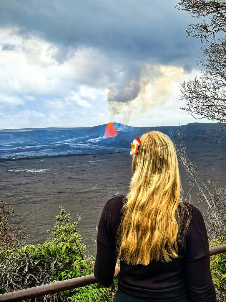 Erupcja Kīlauea na żywo: Jak zaplanować oglądanie lawy na Hawajach? (2026) Turystka obserwująca bezpiecznie wulkan Kīlauea z punktu widokowego na Hawajach.