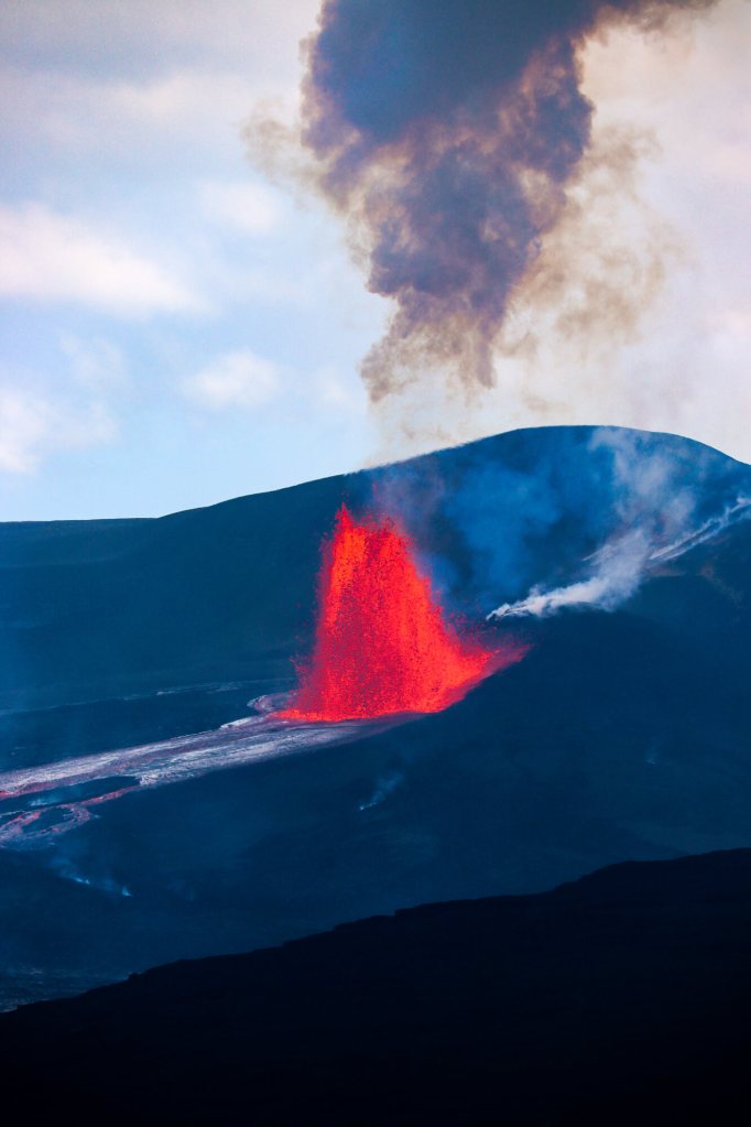 Erupcja Kīlauea na żywo: Jak zaplanować oglądanie lawy na Hawajach? (2026) Fontanna lawy z niebieskim dymem na tle nieba – erupcja Kīlauea