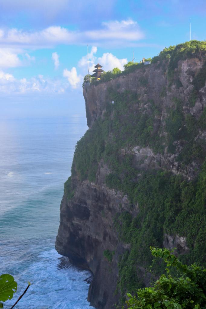 Świątynia Uluwatu, Bali – Kompletny przewodnik Pionowe ujęcie na stromy wapienny klif i pagodę Świątynia Uluwatu na Bali.