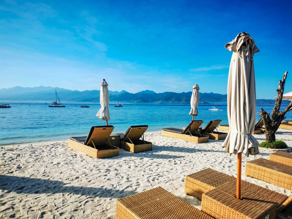 Rajskie wyspy Gili - informacje praktyczne Leżaki i parasole na plaży na wyspach Gili z widokiem na morze