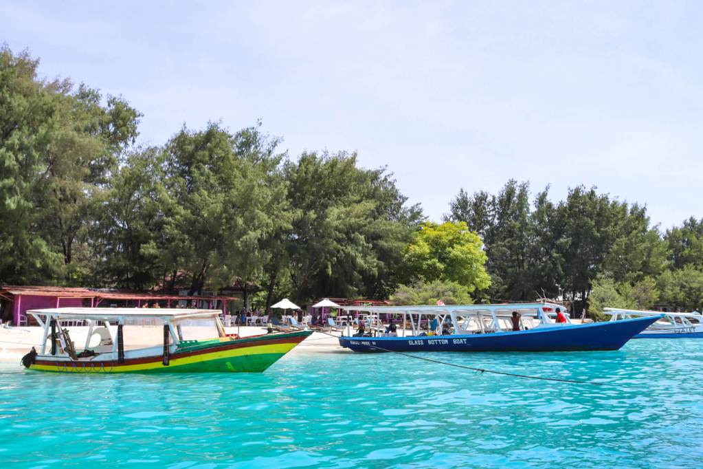 Kolorowe łodzie na turkusowej wodzie przy plaży na wyspach Gili