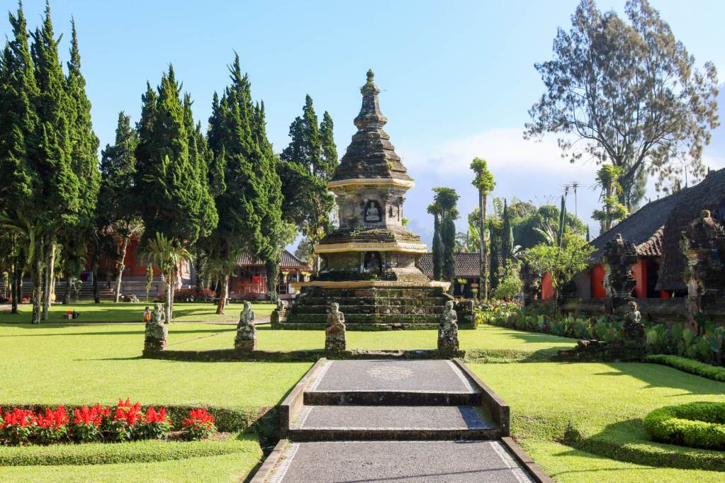 Ogród i kamienna stupa na terenie kompleksu Pura Ulun Danu Bratan na Bali.