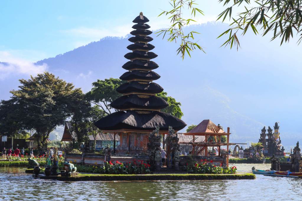 Pura Ulun Danu Bratan na Bali z górami i poranną mgłą w tle.