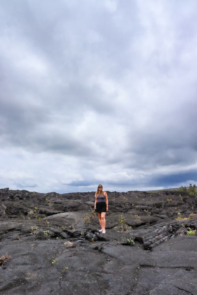 Turystka stojąca na zastygłej lawie na zboczach Kīlauea na Big Island